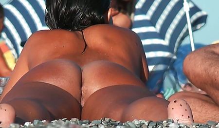 Девушка светит загорелой попой на пляже